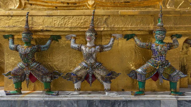Yaksha and monkey figures supporting a golden chedi